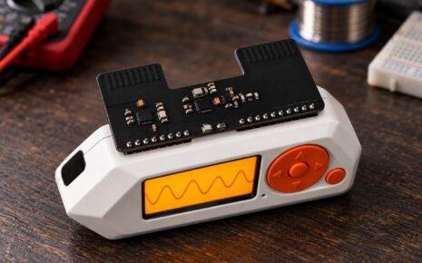 Flipper Zero with the Electronic Cats Sub-GHz and LoRa add-on mounted on its GPIO header, on a workbench